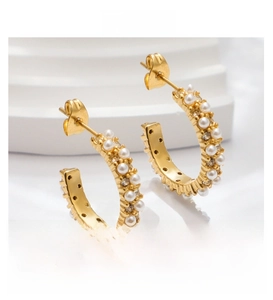Detail view of 18k gold plated C-shaped earrings with pearl and zircon pave settings