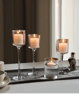 Dettaglio di eleganti portacandele in vetro con candele bianche senza fumo