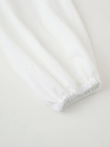 Macro detail of elastic cuffs on white cotton linen blouse with textured fabric finish