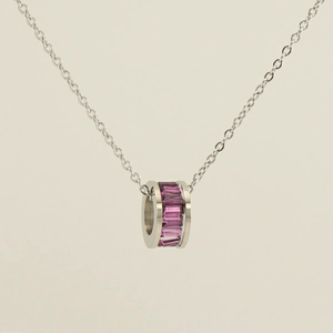 Detailed close-up of a silver stainless steel necklace with a purple crystal ring pendant