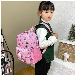 Girl wearing a pink unicorn backpack with rainbow patterns and side mesh pockets