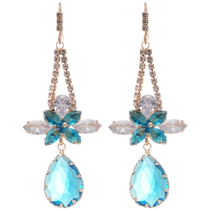 Elegant gold earrings with blue zircon flower and teardrop pendants on white background