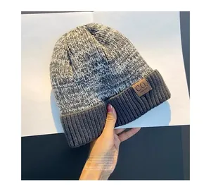 Close-up of the thick knitted gray texture and premium leather label on this winter beanie