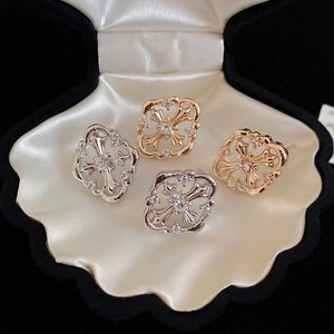 Macro shot of gold and silver gothic cross earrings with sparkling zircon crystals