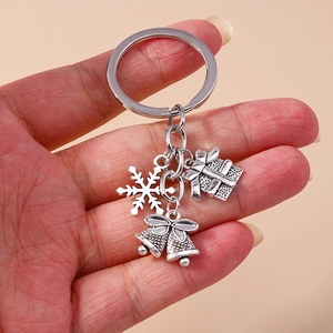 Detail of silver Christmas keychain with snowflake, gift box, and bells charms