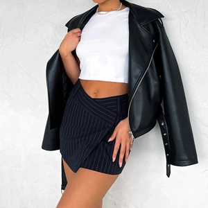 Dettaglio mini gonna a righe a vita alta con crop top bianco e giacca di pelle nera
