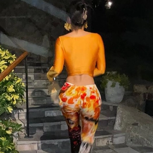 Vue arrière du haut court orange moulant avec pantalon imprimé aux tons chauds