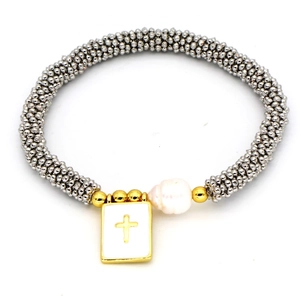 Detail of bohemian silver beaded bracelet with gold cross pendant and white pearl