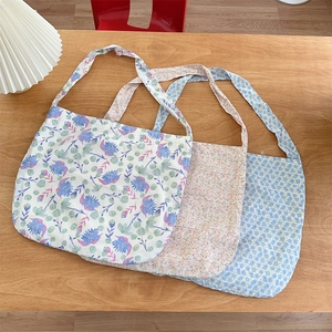 Detailed flat lay of three floral canvas tote bags in purple, pink, and blue flower patterns