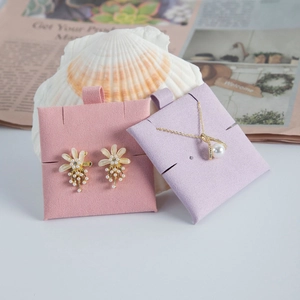 Close-up of pearl jewelry set with flower earrings on pink display card inside a shell
