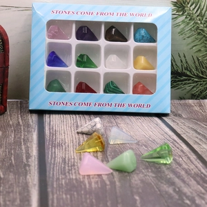 Detail view of 12 natural gemstones in pyramid shapes inside a blue window display box