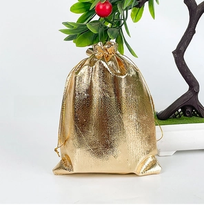 Detailed view of golden metallic drawstring gift bag with fine woven texture and shiny finish