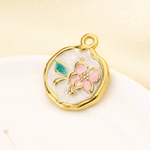 Gros plan d'un pendentif en émail vintage avec fleur rose sur métal doré poli