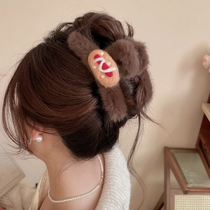 Close-up of brown flocked hair claw clip with cute cookie decoration on blonde hair
