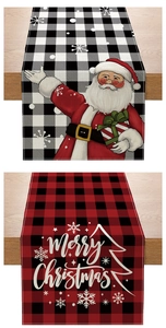Detail of Christmas table runner with festive Santa Claus and plaid pattern on wood table