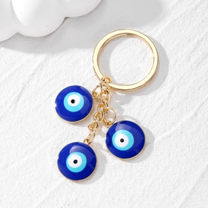 Detail of blue evil eye charms with gold alloy hardware and elegant tassel on keychain