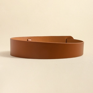 Close-up of minimalist brown leather wide belt with smooth texture for fashion styling