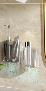 Detail view of wall-mounted bathroom storage cups with drainage holes on marble wall