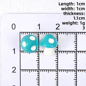 Detailed view of 10mm blue resin mushroom charms with white dots on a measuring scale