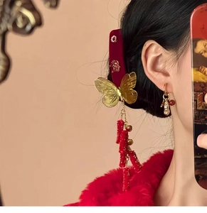 Detail of red tassel hair clip with golden butterfly and festive Xi character charm