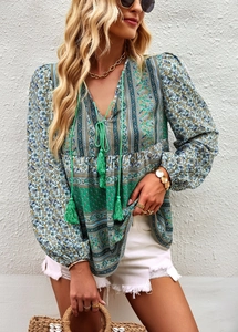 Detail of bohemian blouse featuring contrast floral print with V-neck and tassel drawstrings