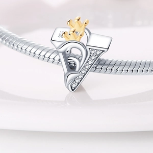 Detailed macro shot of S925 silver heart charm with gold crown and sparkling zircon stones