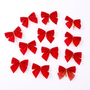 Detailed close-up of twelve red velvet Christmas bows with gold metallic twist ties