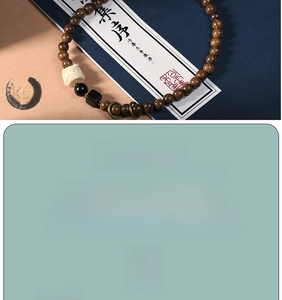 Macro detail of the golden sandalwood beads with engraved white auspicious beast charm