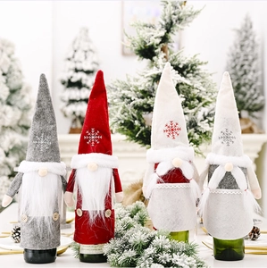 Detailed view of four gnome wine bottle covers with felt hats and snowflake embroidery