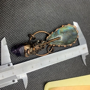 Détail du collier crâne de corbeau avec labradorite mesuré par un pied à coulisse
