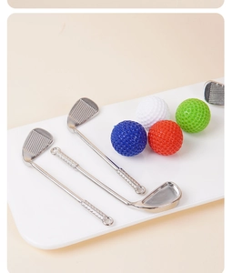 Vue détaillée de trois cuillères en métal en forme de club de golf sur un plat blanc
