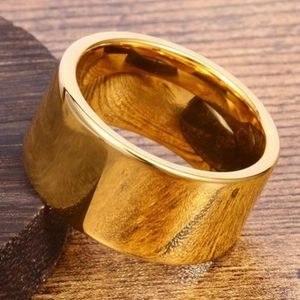 Dettaglio macro di anello d'oro da 12 mm con finitura a specchio su legno