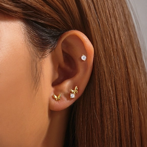 Macro shot of a 925 silver butterfly and zircon stud earring set worn by a model