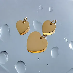 Polished stainless steel heart pendants on a reflective water-drop surface