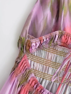 Close-up of elastic smocked waist detail on a colorful tie-dye printed dress fabric