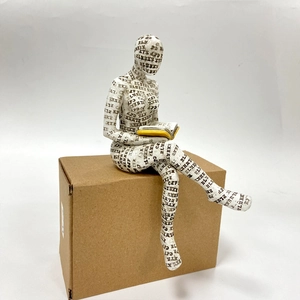 Detailed view of white reading woman sculpture with black typographic patterns