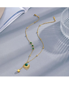 Detailed shot of malachite fan pendant necklace on an elegant light blue textured background