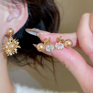 Dettaglio orecchini a lobo a fiore in perla placcati oro 18K con zirconi scintillanti