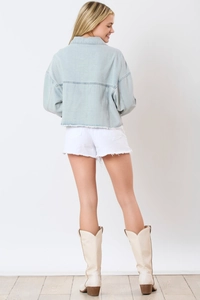 Back view of light blue denim jacket featuring drop shoulders and raw hem detail