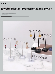 Mini metal and acrylic jewelry stands for earrings and necklaces on marble surface