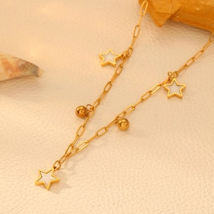 Detail view of gold star pendant necklace with shell inlay on beige leather surface