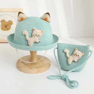 Detail of mint green straw hat and bag set with cute 3D cat doll and woven texture