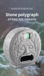 Detail of Stone Polygraph toy with glowing green eyes on rock texture base