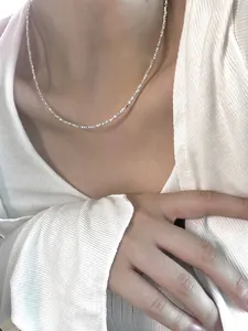 Close-up of minimalist S925 sterling silver ultra-fine shimmering choker necklace on a model