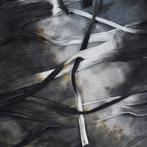 Detailed view of tie-dye fabric with drawstring ties and sheer mesh texture detail