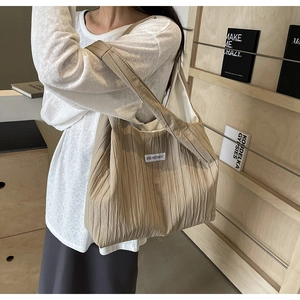 Detail der khakifarbenen Falten-Schultertasche mit KISS YOURSELF-Etikett und Textur