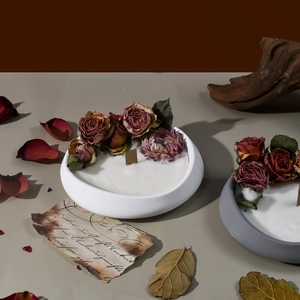 Primer plano de velas aromáticas en cuencos de piedra decoradas con capullos de rosa