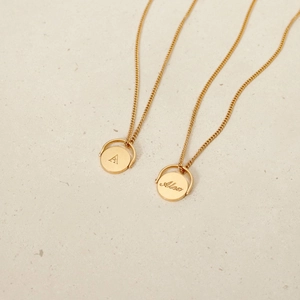 Gold oval stainless steel necklace with spinning pendant featuring initial A and Alex