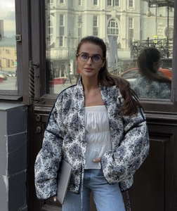Scatto street style di una giacca trapuntata con stampe vintage su fondo bianco