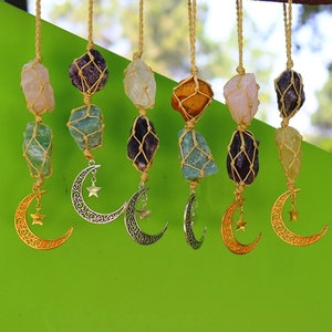 Detailed view of hand-woven net pouches with natural raw crystals and star moon charms